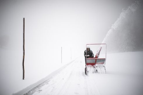A man clears a path in the snow in St Margrethenberg, Switzerland. The east of Switzerland received the first snow of this winter. Photograph: Gian Ehrenzeller/EPA