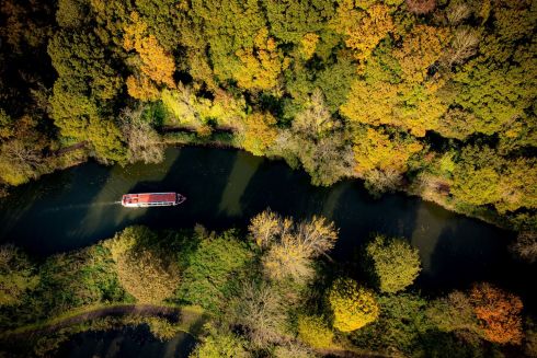 RIVER RUNS THROUGH IT: A river boat makes its way through autumnal trees alongside the River Avon as it flows through Conham and St Annes, east Bristol, England, on a cold, clear November day. Photograph: Ben Birchall/PA Wire

