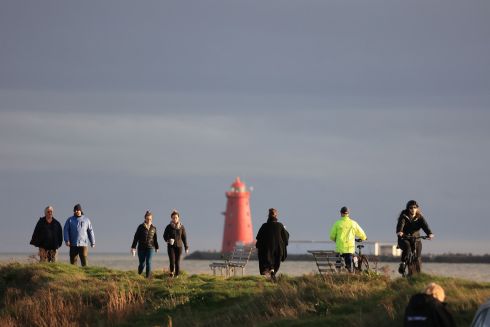 MILD DAY FOR IT: Walkers and a cyclist make their way along the Bull Wall at Clontarf, Dublin. Photograph: Nick Bradshaw 