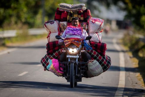 EXTRA CUSHIONING: A vendor carries mattresses and cushions for sale on the back of a motorbike, in Gauhati, India. Photograph: Anupam Nath/AP Photo
