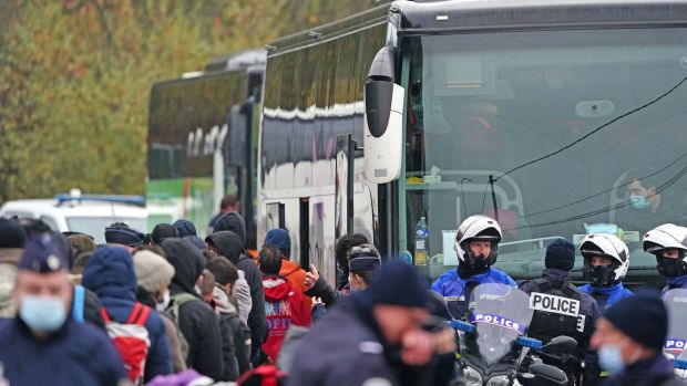 Migrants board a bus near the camp in Grande-Synthe, east of Dunkirk, as French police evacuate the site. Photograph: Gareth Fuller/PA