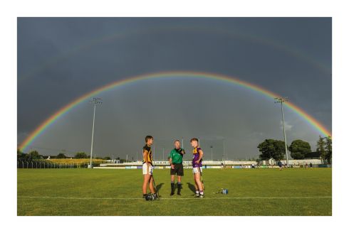 28 July 2021; Somewhere under the rainbow. Nature provides the perfect setting, a multi-coloured domed roof  in Carlow for one of Leinster's great rivalries. Kilkenny minor hurling captain Harry Shine and his opposite number, Wexford's Luke Murphy, wait to see how referee Thomas Gleeson's coin lands before choosing ends. No crock of gold for the winners but they'll settle for silverware. Photo by Matt Browne/Sportsfile 