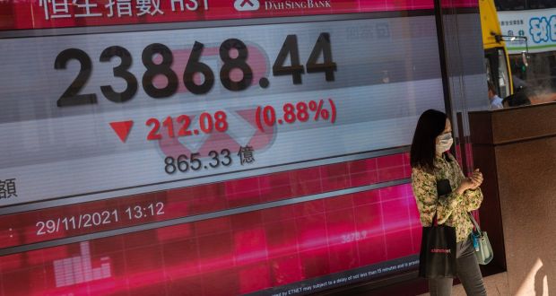   A woman stands next to an electronic board displaying the Hang Seng Index Hong Kong. Photograph: Jerome Favre/EPA