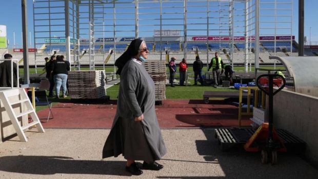 A nun looks at workers preparing the stage at Nicosia’s GSP football stadium, where Pope Francis is scheduled to conduct a holy mass in the Cypriot capital later this week. Photograph: Christina ASSI/AFP