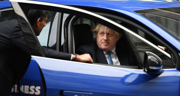 Rishi Sunak and Boris Johnson shoot the breeze as Johnson poses in an electric vehicle branded ‘Small Business Saturday’. Photograph: Daniel Leal/AFP
