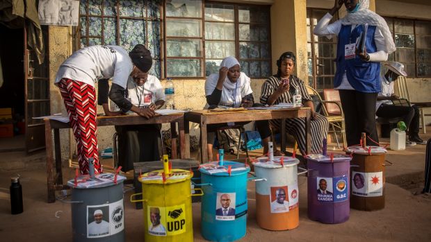 Gambians vote by placing marbles in drums with the presidential candidates’ faces on them. Photograph: Sally Hayden