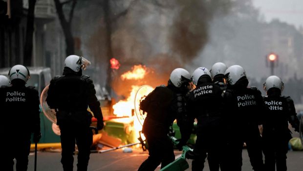 Belgian riot police stand in position as clashes erupt during a demonstration against the government’s measures to curb the spread of Covid-19, in Brussels. Photograph: Kenzo Tribouillard/AFP via Getty Images