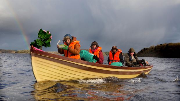 Colum Stapleton, Jessica Reid and Renato Mela are ferried from Trinity Island on Lough Key by Finian Dodd, during the ceremonial transfer of the annals on Monday. Photograph: Brian Farrell