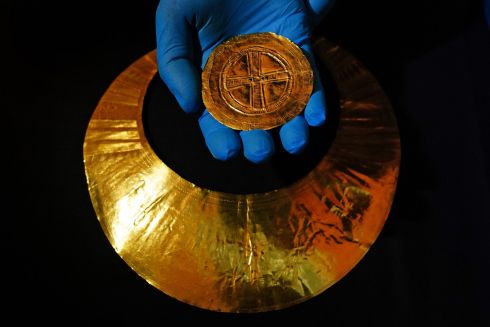 PRECIOUS METAL: A staff member holds a portable sun-disc, dated 2400-2000 BC and found in Co Wexford, which will go on display at the British Museum in London for its forthcoming The World of Stonehenge exhibition. Photograph: Victoria Jones/PA Wire
