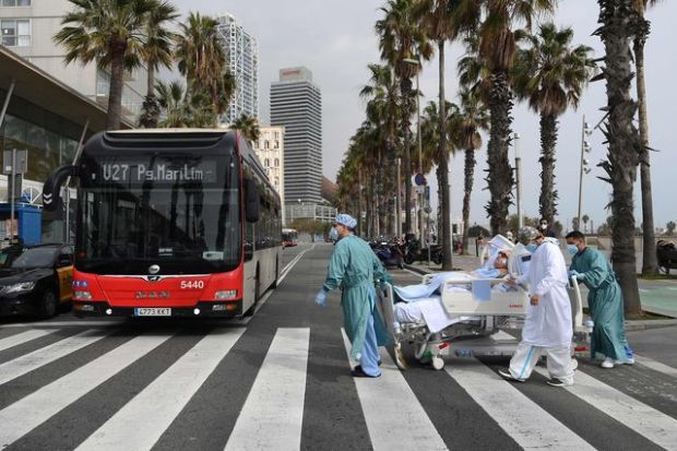 Medical personnel of Hospital del Mar take Covid-19 patient, Marta Pascual, back to the hospital after getting some fresh sea air in Barcelona, Spain. Photograph: Lluis Gene/AFP