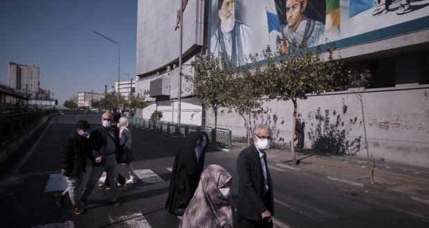 Families  walk under a portrait of Iran’s supreme leader Ayatollah Ali Khamenei in Tehran.  In 2019, 900 university professors left the county. Photograph: Morteza Nikoubazl/NurPhoto via Getty Images