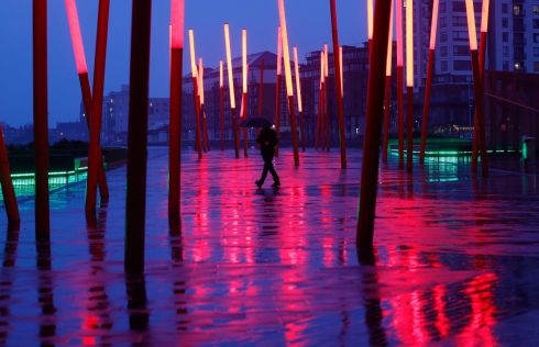 HIT THE LIGHTS: A walker in the rain crossing Grand Canal Square in Dublin's Docklands. Photograph: Alan Betson
