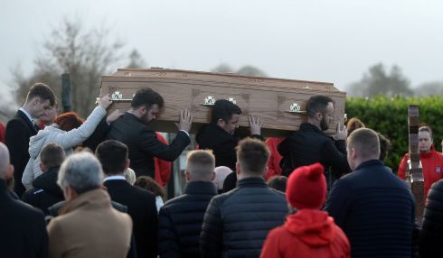 FINAL GOODBYE: Family members touch the coffin of Nathan Corrigan (20), as it is carried from St Matthew's Church, Garvaghy, Co Tyrone, for burial in the adjoining cemetery. He died with friends Petey Mcnamee (20), and Peter Alexander Finnegan (21) in a collision involving a lorry on the A5 at Garvaghy on Monday. Photograph: Oliver McVeigh/PA Wire
