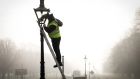 An OPW contractor cleans the glass on one of the gas-lit street lamps in Phoenix Park. Photograph: Crispin Rodwell