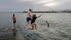 Jack Byrne, Paddy Davis, Naoise Dunne, Mark Fitzgibbon and Hannah Ring from Dublin and Athlone jump in for a quick dip at Clontarf. Photograph: Alan Betson/The Irish Times


