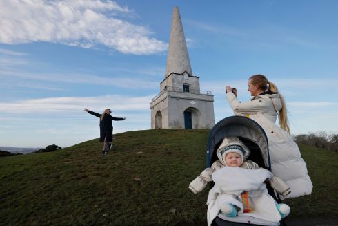 SUNNY SENSATION: Tina Supraha, Tjasa Zapusek and Jon Sven Misic (1), from Dún Laoghaire, take photos beside the Killiney Obelisk on top of Killiney Hill while out walking in the sun. Photograph: Alan Betson