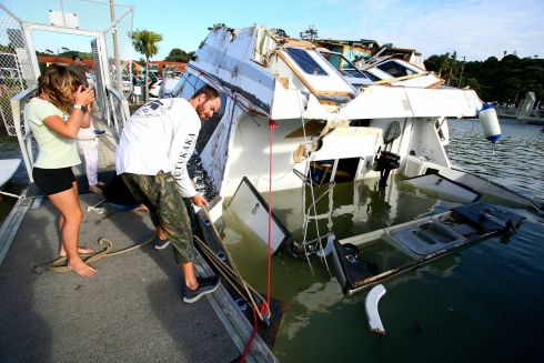 TSUNAMI DAMAGE: People attempt to secure a damaged boat in a marina at Tutukaka, New Zealand, after a tsunami resulting from a volcanic eruption near Tonga swept through. Photograph: Tanya White/Northern Advocate/NZME/AP
