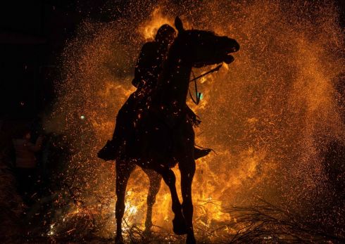 BAPTISM OF FIRE: A horseman rides through a bonfire in the village of San Bartolome de Pinares, province of Avila, central Spain, during the traditional religious festival of Las Luminarias in honour of San Antonio Abad (St Anthony), the patron saint of animals. Photograph: Pierre-Philippe Marcou/AFP/Getty
