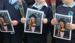 Ashling Murphy’s first-class pupils from Durrow National School hold a photo of their teacher outside the Church of St Brigid, Mountbolus, Co Offaly. Photograph: Gareth Chaney/Collins Photos