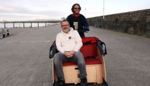 Steve Slusarski pedals Stephen McManus, founder The Bike Hub on Dun Laoghaire Pier. Photograph: Laura Hutton