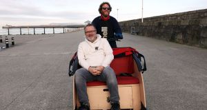 Steve Slusarski pedals Stephen McManus, founder The Bike Hub on Dun Laoghaire Pier. Photograph: Laura Hutton