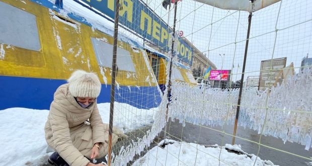 Olha Volkova, a teacher in Kharkiv close to Ukraine’s border with Russia, ties strips of white cloth to a camouflage net that will be sent to soldiers fighting Moscow-led separatists 300km away. Photograph: Daniel McLaughlin