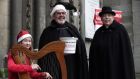 Emily Breslin, a student at Alexandra College plays the harp as Fred Dean and Terry Lilburn from St Anns Church on Dawson Street launch their 2021 annual Black Santa Appeal for charities in Dublin. Photograph: Damien Eagers for The Irish Times