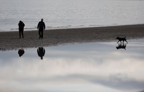 SELF-REFLECTION: Walkers and their dog reflected in the tide on Sandymount Strand in Dublin.  Photograph: Nick Bradshaw