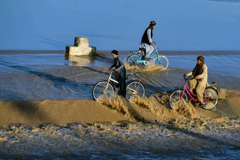 FLOOD WATERS: Boys ride bicycles on the flood waters flowing along a stream in the Daman district of Kandahar in Afghanistan. Photograph: Javed Tanveer/AFP via Getty
