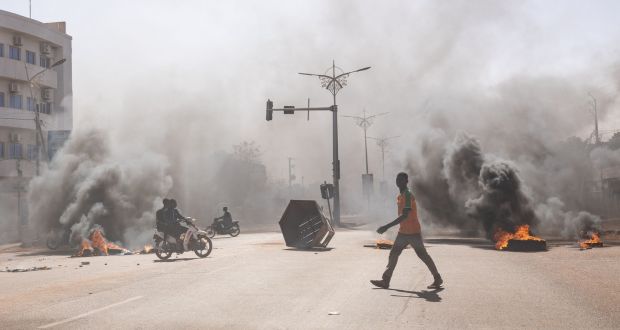 A man crosses through burning barricades in central  Ouagadougou on Sunday. Photograph: Olympia de Maismont/AFP via Getty Images