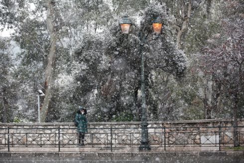 GREEK STATUE: A woman stands still beside a wall during snowfall in central Athens, Greece. A bad weather front named Elpis by the National Meteorological Services has brought frozen temperatures, stormy winds and heavy snowfall and is expected to continue into January 25th. Photograph: Yannis Kolesidis/EPA
