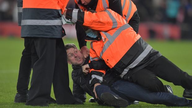 Stewards catch a pitch invader after the Premier League match between Southampton and Manchester City at St Mary’s Stadium. Photograph: Vince Mignott/EPA