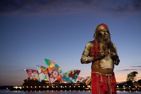 Koomurri performer Lee Daniels is seen as artwork by Pitjantjatjara man Yadjidta David Miller is projected onto the sails of the Sydney Opera House at dawn during Australia Day 2022 celebrations, in Sydney, Australia on Wednesday. Photograph: Biance De Marchi/EPA/Australia and New Zealand Out

