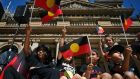 Children wave the Aboriginal flag at a protest in Sydney on Wednesday. Photograph:  Steven Saphore/AFP via Getty Images