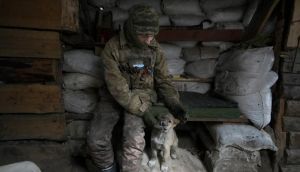 A Ukrainian serviceman pats a dog sitting in a shelter on the front line in the Luhansk region, eastern Ukraine on Friday. Photograph: Vadim Ghirda/AP