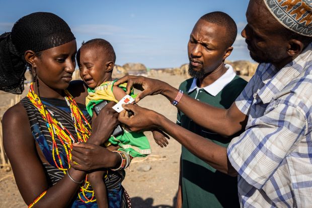 Sallo Okile (16) with her baby Adho Okile, who receives a health check from Molu Bukato, alongside Concern’s health and nutrition manager Kennith Wambugu. Photograph: Ed Ram/Concern Worldwide