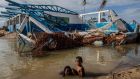 Children bathe next to a destroyed house in Haulover, some 41km south of Bilwi, in the Northern Caribbean Autonomous Region, Nicaragua, days after the passage of Hurricane Iota. Photograph: Inti Ocon/AFP via Getty