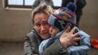 A woman holds her child as she tries to board a free train to Poland at a station in Lviv, western Ukraine, on Thursday. Photograph: Daniel Leal/AFP via Getty Images