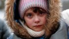 A Ukrainian refugee looks on while waiting to be transported after she and her mother managed to cross the Romanian-Ukrainian border crossing point in Siret, northern Romania on Friday. Since the outbreak of the conflict, 187,687 refugees from Ukraine have entered Romania, and 126,502 have left the country for other destinations, according to the latest report of the Border Police. Robert Ghement /  EPA