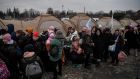 Refugees wait to be transported after crossing the Ukrainian-Polish border at the border crossing in Medyka, southeastern Poland. Photograph: Louisa Gouliamaki/AFP via Getty