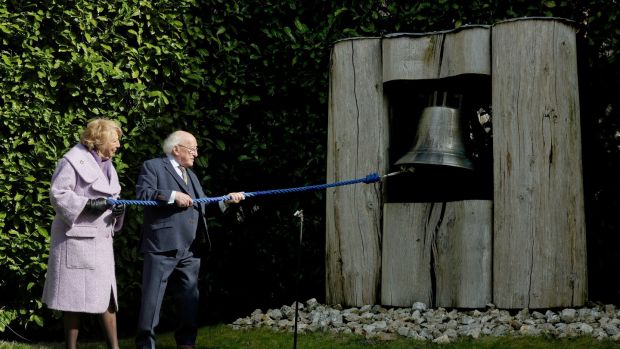 President Michael D Higgins and Sabina Higgins ring the Peace Bell in the grounds of Áras An Uachtaráin during the remembrance ceremony for those who died from coronavirus, those grieving and frontline workers.