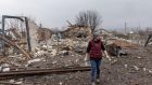 A woman stands amid the debris of destroyed homes in Boromlya, Ukraine. Boromlya lies 40km south of Sumy, the regional capital, which has been heavily bombarded by Russian forces. Photograph: Chris McGrath/Getty