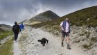 Thomas O’Malley and his dog Lassie of Thornhill, Lecanvey, Co Mayo, make their way back down Croagh Patrick, as pilgrims head in the opposite direction. 