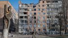  A Russian soldier walking in front of  destroyed apartment buildings  in Donetsk, Ukraine. Photograph: Sergei Ilnitsky/EPA