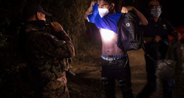 A Salvadoran soldier searches a man for gang tattoos in a gang-controlled neighbourhood in Tonacatepeque, El Salvador. Photograph: Daniele Volpe/The New York Times