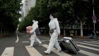 People wearing PPE cross a street with their luggage near an area on lockdown due to the recent Covid-19 outbreaks in Beijing on May 10th. Photograph: Noel Celis/AFP via Getty Images