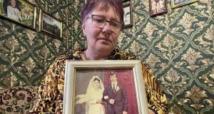 Lyubov Leus holds a photo of her with her husband, Serhiy, on their wedding day nearly 40 years ago. Serhiy was shot and badly injured by Russian troops outside their house. He and their son Sasha (32) were  shot dead in their car later in the day as they attempted to drive  to a nearby hospital. Photograph: Daniel McLaughlin