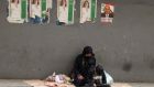 A beggar and her children sit beneath electoral posters under a bridge in the Lebanese capital Beirut. Photograph: Anwar Amro/AFP/Getty 