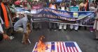 Supporters of Palestine Foundation Pakistan  burn Israel and US flags and display placards of  slain journalist Shireen Abu Akleh in Karachi. Photograph: Rizwan Tabassum/AFP