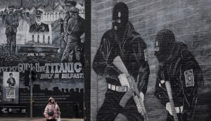  A woman walks past a Loyalist paramilitary mural on the Newtownards road in Belfast. An inquiry into the effect of paramilitarism on society heard that these groups  do prey on communities and  commit crime,  but in some instances  are seen as protecting the community as well. Photograph: Charles McQuillan/Getty 